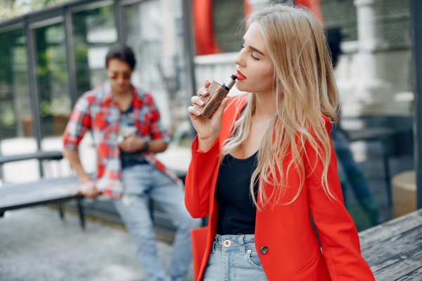 Women vaping with a man in the background and the image is purely decorative